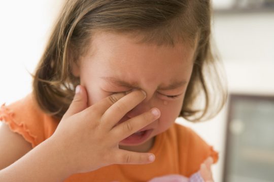 Young girl indoors crying